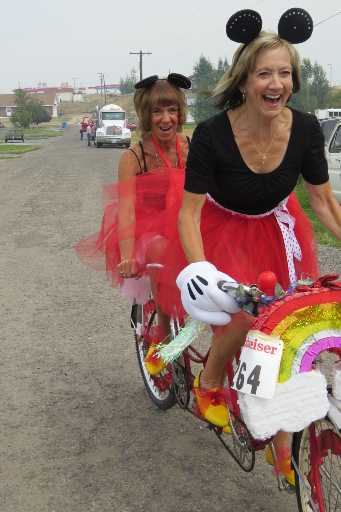 Bobbie Janacaro, in front, and her sister, Jannie Lewis, ride a tandem bike, readying for the parade during the 2015 Jefferson County Fair and Rodeo